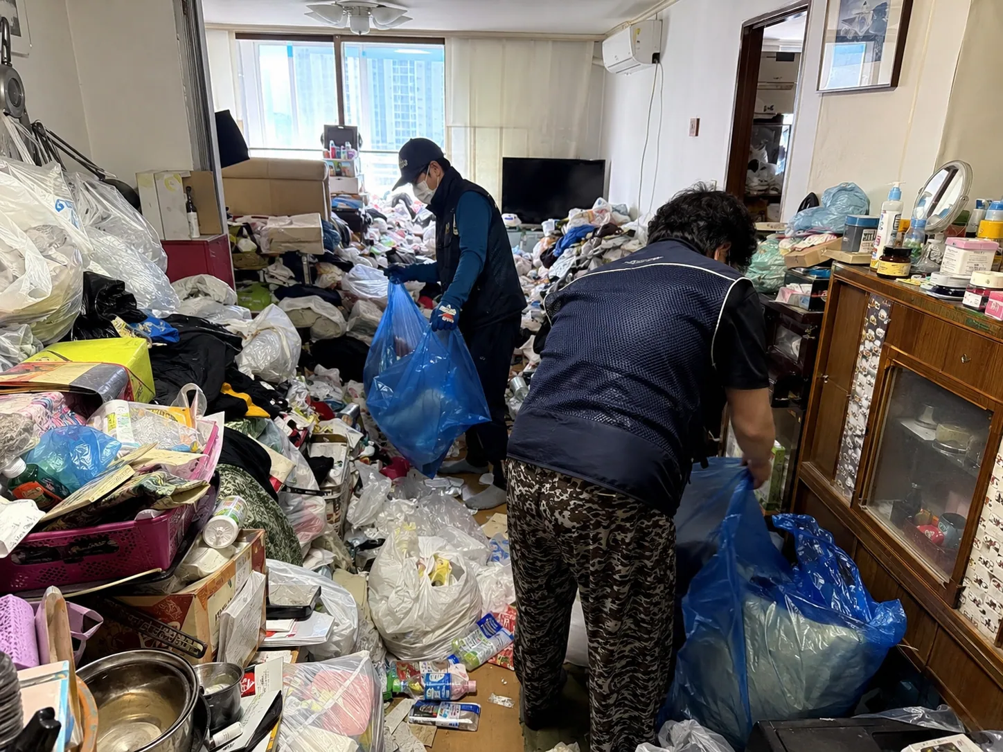 쓰레기집 적치물 반출 후 공간을 청소하는 작업 현장